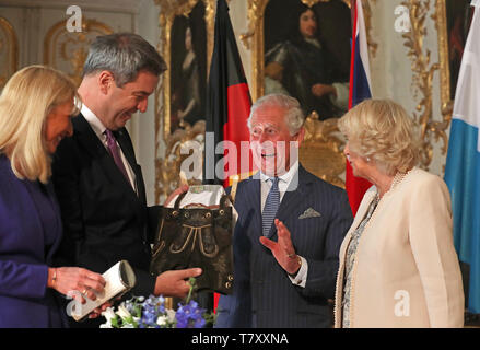 The Prince of Wales and the Duchess of Cornwall are given a pair of baby lederhosen as they are officially welcomed to Munich, Germany, in an event hosted by the Minister-President of Bavaria Markus Soder. Stock Photo