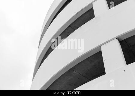 Modern parking lot, round white concrete building exterior, abstract fragment Stock Photo