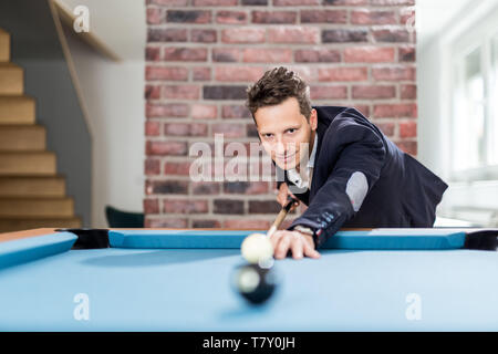 Portrait of fashionable man playing billiards. Stock Photo