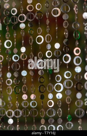 A curtain of round shiny metal circles in warm atmosphere. Stock Photo