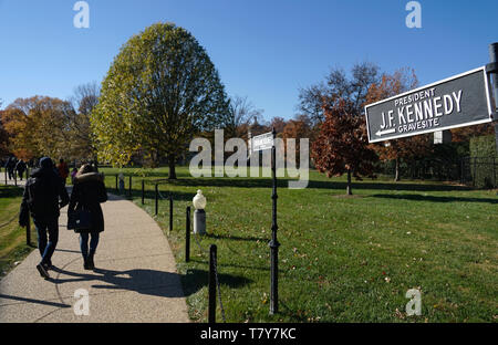 Direction sign of President J.F.Kennedy gravesite with visitors in background in Arlington National Cemetery.Arlington.Virginia.USA Stock Photo