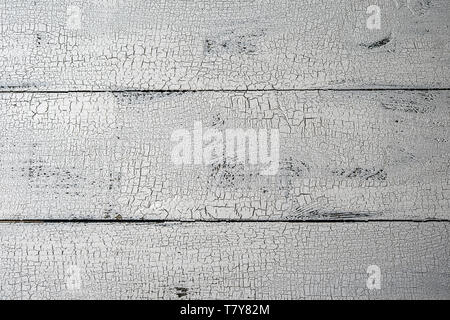 Close-up of natural wooden planks painted in white color with craquelure effect. Textured white and grey aged background with horizontal layout and co Stock Photo