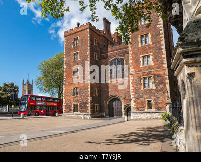 Lambeth Palace London. Morton's Tower with Parliament and red London Bus. Red brick Tudor gatehouse forming the entrance to Lambeth Palace London UK Stock Photo