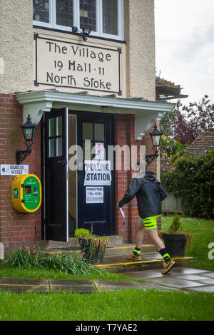 A man dressed in running gear goes to cast his vote in the Polling Station in North Stoke Village Hall, Oxfordshire. Stock Photo