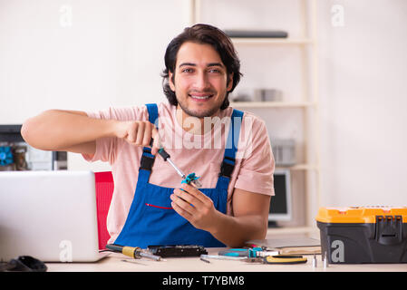Young male contractor repairing computer Stock Photo