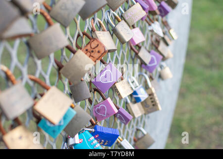 Love locks focusing on a purple lock with white heart Stock Photo