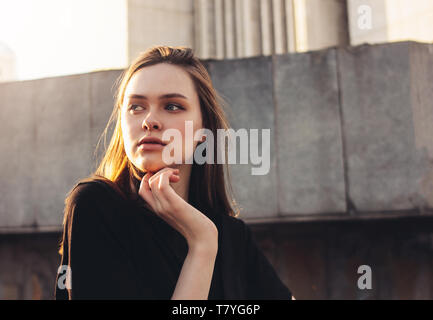 Close up portrait of beautiful long hair girl fashion model on sunset at city street Stock Photo