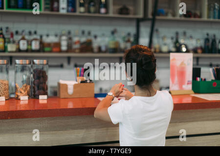 young attractive woman makes an order in a cafe Stock Photo