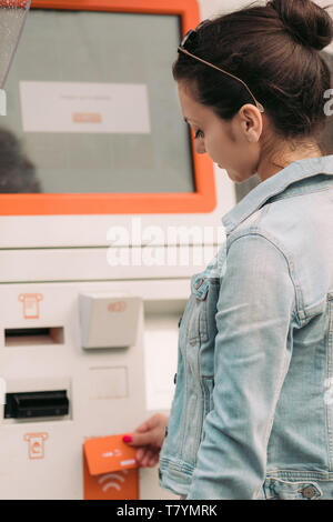 Tourist woman buys tickets for transport in Georgia. modern street machine for purchase of tickets for bus Stock Photo