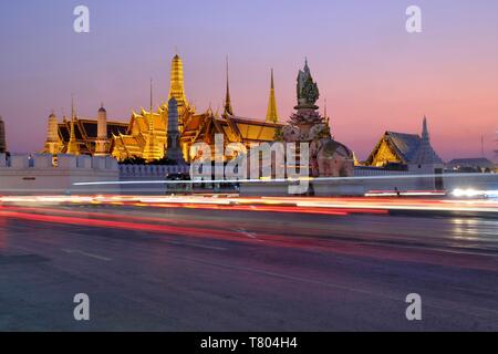 Illuminated royal palace Wat Phra Kaeo at dusk, light tracks on street, Bangkok, Thailand