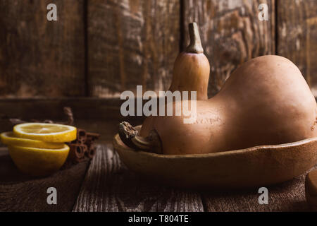 Raw fresh pumpkin, cooking ingredients, autumn traditional vegetable dish preparation, rural wooden table, close up, selective focus Stock Photo