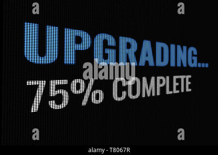 Upgrading 75% complete word on dark screen, tv effect. Stock Photo