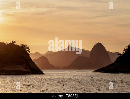 View over rocks of Piratininga towards Rio de Janeiro, sunset, Niteroi, State of Rio de Janeiro, Brazil, South America Stock Photo
