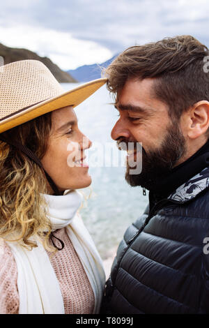 Heterosexual couple looking each other about to kiss in Potrerillos dam, Mendoza, Argentina Stock Photo