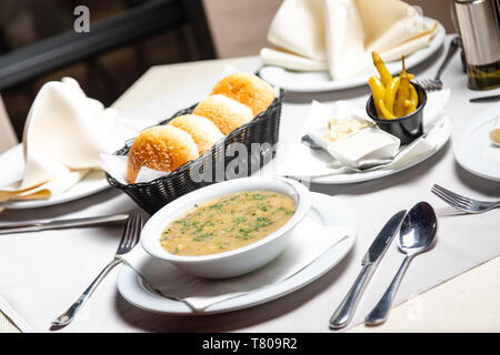 Traditional Balkan beef soup in Restaurant with garnish, peppers, bread Stock Photo