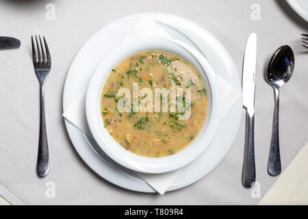 Traditional Balkan beef soup in Restaurant with garnish, peppers, bread Stock Photo