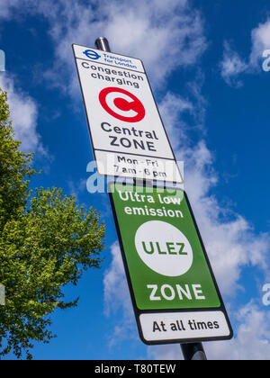 'ULEZ' TFL congestion/emission charging central London zone sign with 'ULEZ' ultra low zone sign against blue sky with tree in fresh green leaf  SE11