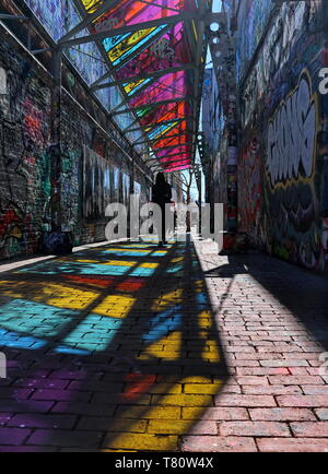 woman walks through graffiti alley in Cambridge, MA (april 17, 2019) Stock Photo