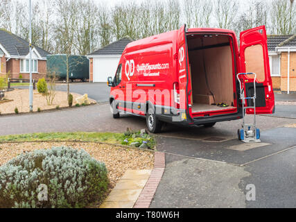 Red QD Quality Discount store delivery van making a home delivery Stock Photo