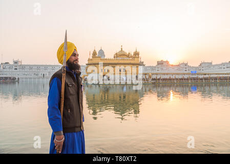 Guard standing by tank, the Golden Temple, Amritsar, Punjab, India, Asia Stock Photo