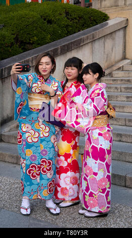 Young Japanese women dressed in colourful kimonos taking selfies in Kyoto, Japan, Asia