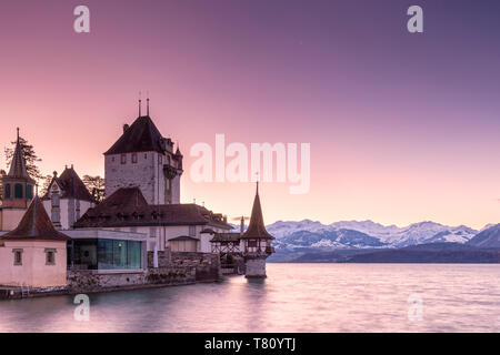 Sunrise at the castle of Oberhofen am Thunersee with the snow-covered Bernese Alps, Canton of Bern, Switzerland, Europe Stock Photo