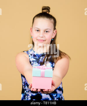 Thank you so much. Child hold gift box beige background. Kid girl delighted gift. Girl adorable celebrate birthday. Kid happy loves birthday gifts. Shopping and holidays. Share and generosity. Stock Photo