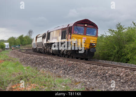 DB cargo class 66 locomotive passing Crofton, Wiltshire with a freight train carrying aggregates for Hanson Stock Photo