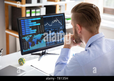 Businessman Looking At Dashboard Analyzing KPI Graph On Computer Stock Photo
