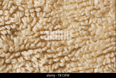 Texture cotton bath towel macro, background of a woven fabric, light tan colour. Stock Photo