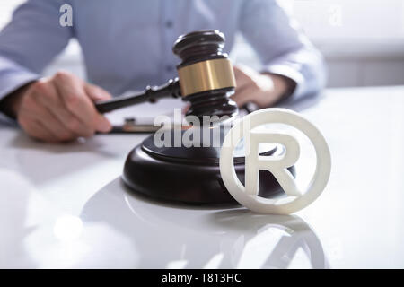 Close-up Of Judge Striking Mallet On Trademark Copyright Symbol Stock Photo