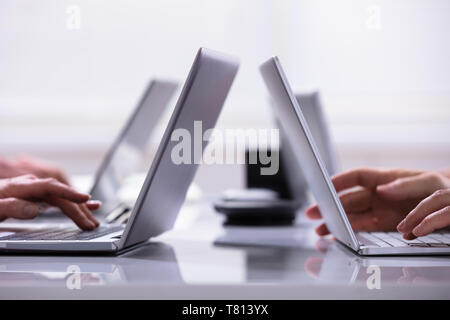 Close-up Of A Businessman Hands On Laptops Keypads On Desk In Office Stock Photo