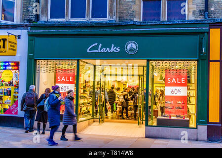 Shoppers walking past the outside of a Clarks shoe shop on a busy street in Oxford, UK. December 2018. Stock Photo