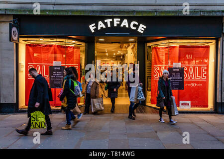 Shoppers outside a Fatface Fat Face clothes shop with posters advertising a sale in the windows. Oxford, UK. December 2018. Stock Photo