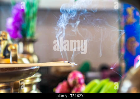 Incense on the brass candlestrick with the smoke out from incense. Stock Photo