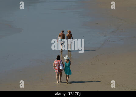 Older senior couple walking in front of two female friends on beach, Durban, KwaZulu-Natal, South Africa, people, active, health, leisure Stock Photo