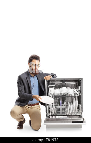Bearded man loading a dishwasher isolated on white background Stock Photo