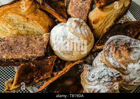 Traditional Armenian biscuit "Gata" and baklava of puff pastry, pieces of various cakes and eclairs on a porcelain plate Stock Photo