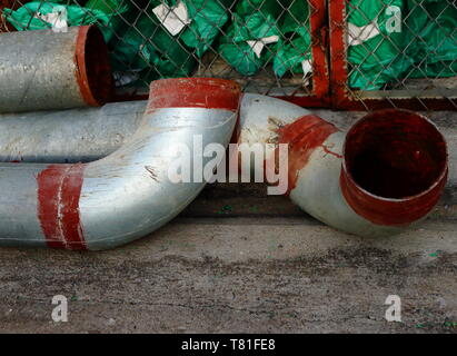 Closeup of part of large metal pipes on concrete floor Stock Photo