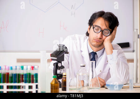 Young funny chemist in front of white board Stock Photo