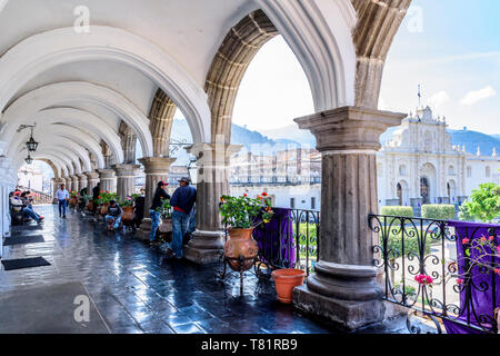 Antigua, Guatemala - April 10, 2019: View of San José cathedral & central park through city hall arches in colonial town & UNESCO World Heritage Site. Stock Photo