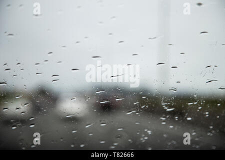 Stuck in traffic on State highway 1 New Zealand on a rainy cloudy afternoon. Cars blurred on the road in front rain drops in focus on front windscreen Stock Photo