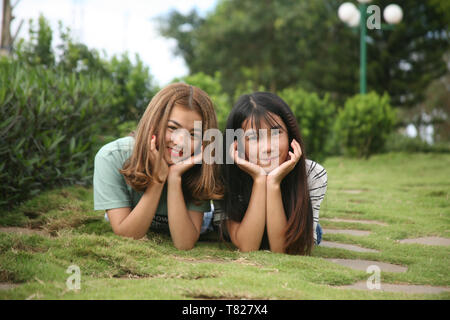 photo of two girls lying on a grass Stock Photo