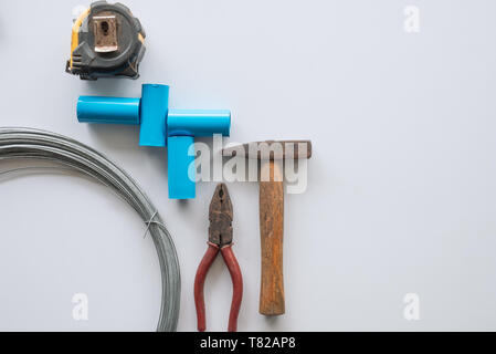 Tools for home repair with rust pliers, hammer, pipe, wire, measuring tape on white background Stock Photo