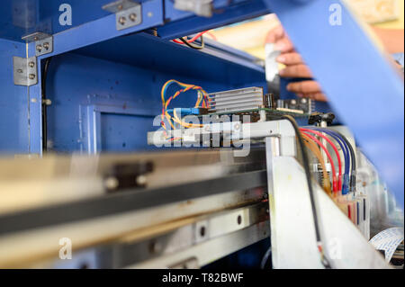 Technician repairing mainboard of colors dispensers of inkjet printer in workplace Stock Photo