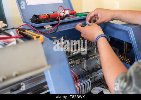 Technician repairing mainboard of colors dispensers of inkjet printer in workplace Stock Photo
