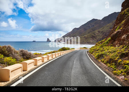 Scenic ocean road by cliffs of the Macizo de Anaga mountain range, Tenerife, Spain.
