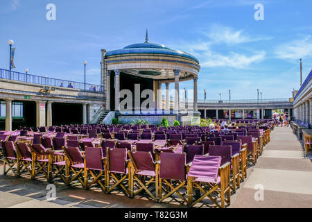 Eastbourne, Sussex, UK - August 1, 2018:  Famous art deco bandstand in Eastbourne, Sussex.  Taken on a sunny summer's afternoon with people relaxing i Stock Photo
