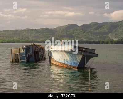 Many ship wrecks laying on the coast of the island of Ambon in Indonesia. Ambon Island, Central Maluku, Indonesia Stock Photo