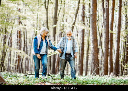 Senior couple walking together in the forest, enjoying nature and free time on their retirement Stock Photo
